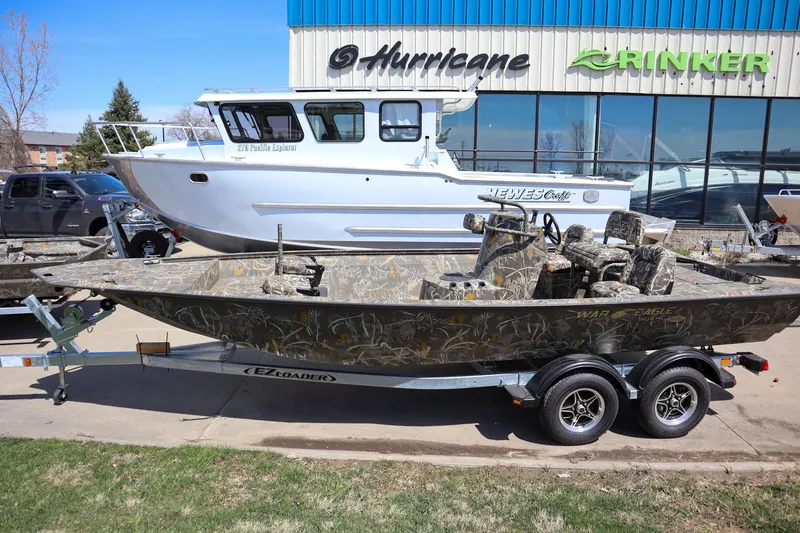 Slide: The Image of 2024 War Eagle 2170 Blackhawk boat on trailer outside dealership. - 1