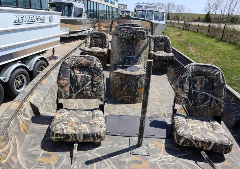 Slide: The Image of 2024 War Eagle 2170 Blackhawk boat with camo seats and console, parked outdoors. - 4