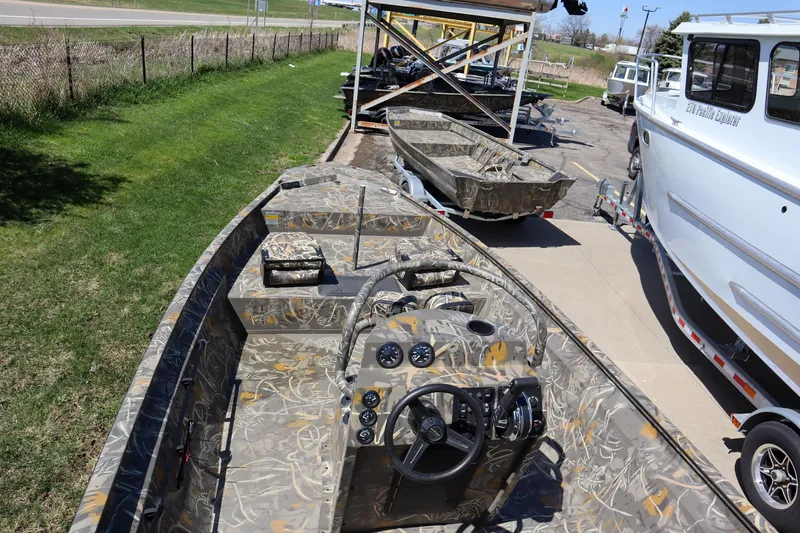 Slide: The Image of 2024 War Eagle 2170 Blackhawk boat with camouflage interior, parked on a trailer. - 7
