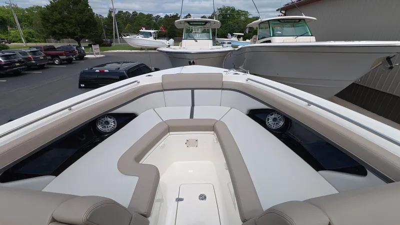 Slide: The Image of The image shows the bow area of a 2025 Boston Whaler 330 Vantage. There are cushioned seats and speakers. - 29