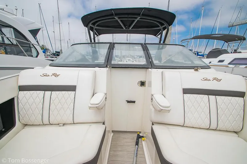 Slide: The Image of 2017 Sea Ray SLX 280 boat interior with white seating and black accents at a marina. - 24