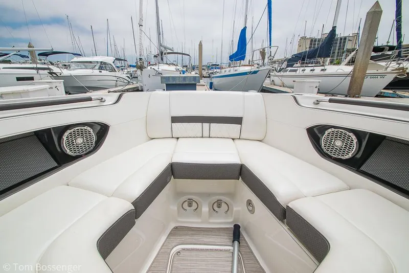 Slide: The Image of 2017 Sea Ray SLX 280 boat interior with white seating, docked among sailboats. - 25