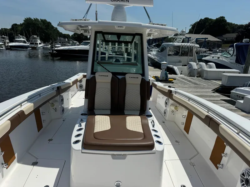 Slide: The Image of 2024 Caymas 34 CT boat interior at marina, featuring seating and navigation equipment. - 12