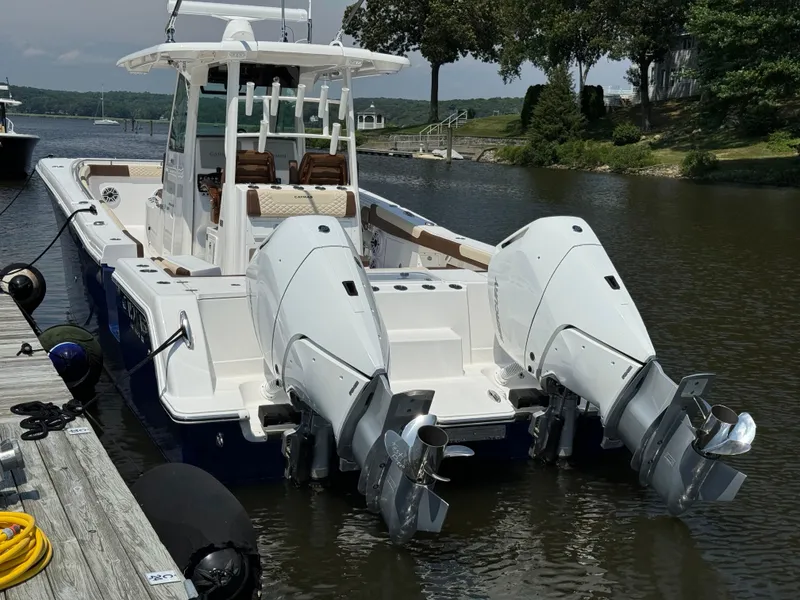 Slide: The Image of 2024 Caymas 34 CT boat docked with twin outboard engines. - 2