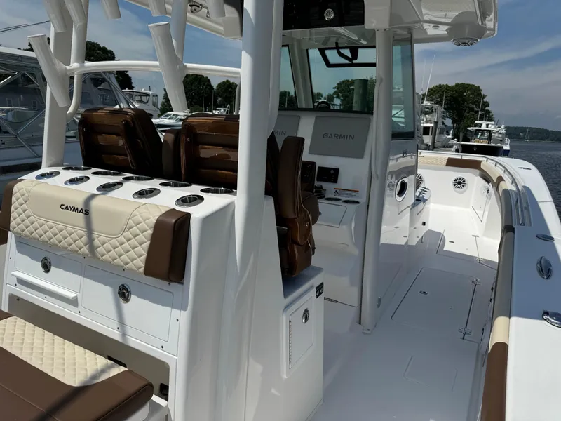 Slide: The Image of 2024 Caymas 34 CT boat interior with brown and white seating, docked at marina. - 3