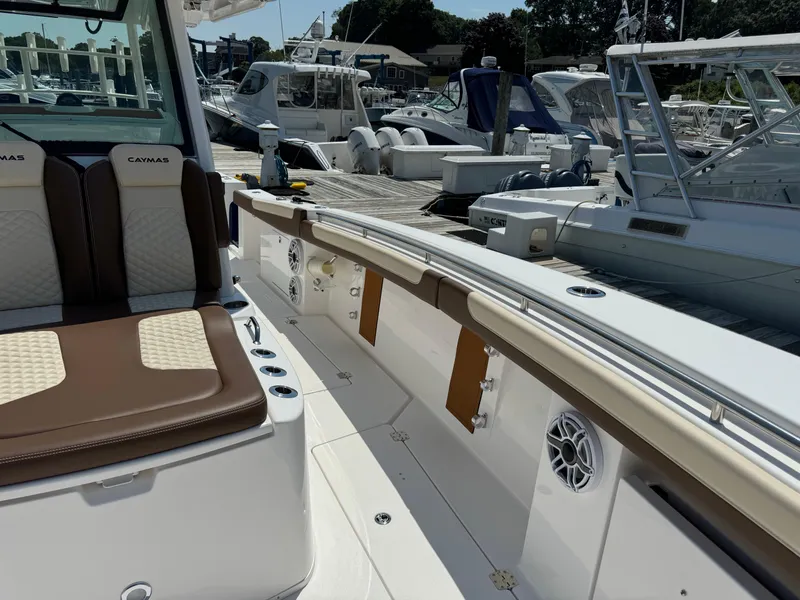 Slide: The Image of 2024 Caymas 34 CT boat interior at marina, featuring cushioned seating and modern amenities. - 9