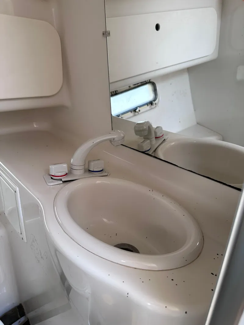 Slide: The Image of 1996 Maxum 2400 SCR boat bathroom sink with mirror and faucet. - 11
