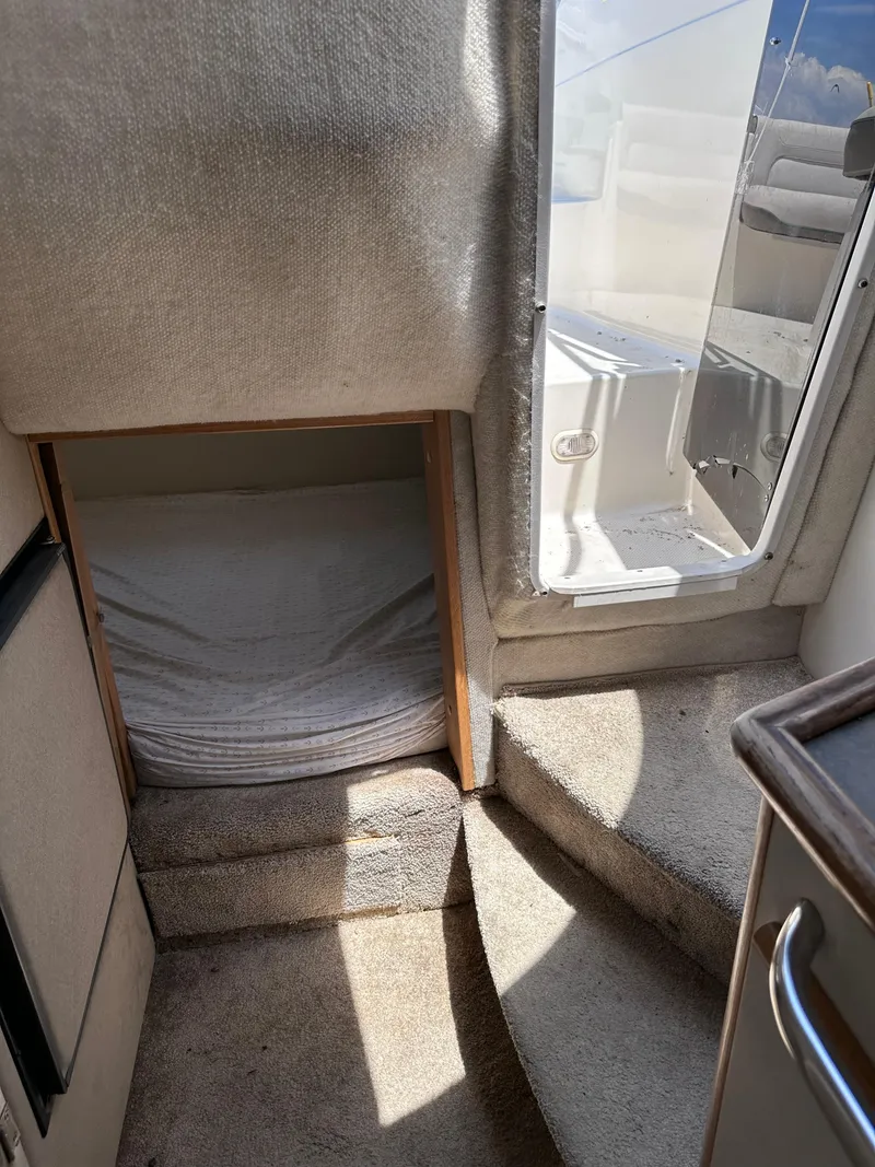 Slide: The Image of Interior cabin of a 1996 Maxum 2400 SCR boat with steps and sleeping area. - 12