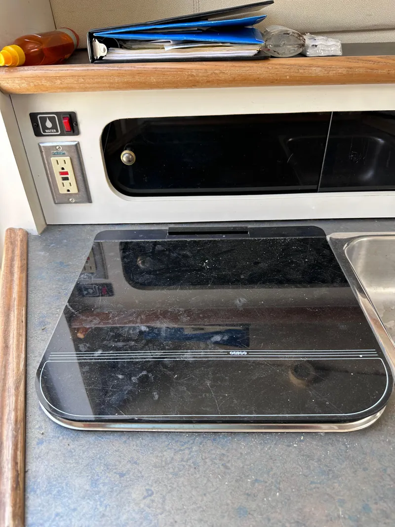 Slide: The Image of 1996 Maxum 2400 SCR boat interior with stove, sink, and storage. - 13