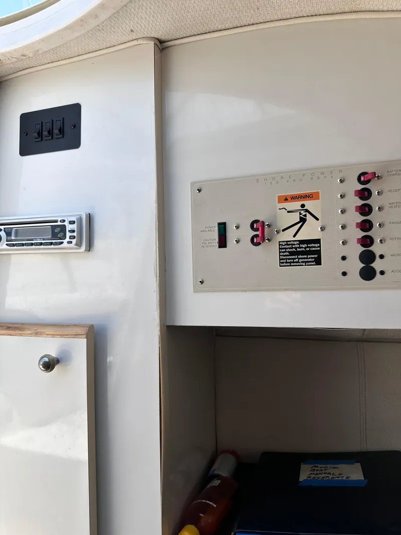 Slide: The Image of Control panel and storage area inside a 1996 Maxum 2400 SCR boat. - 15