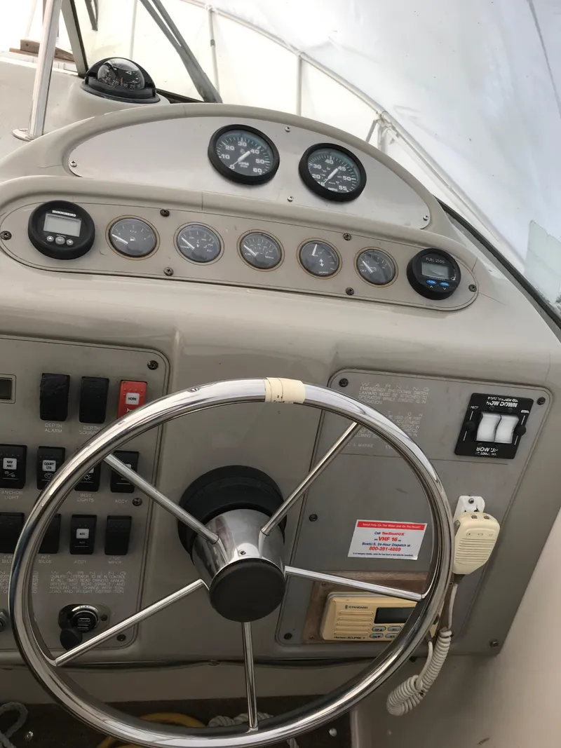 Slide: The Image of 1996 Maxum 2400 SCR boat dashboard with steering wheel and control gauges. - 22