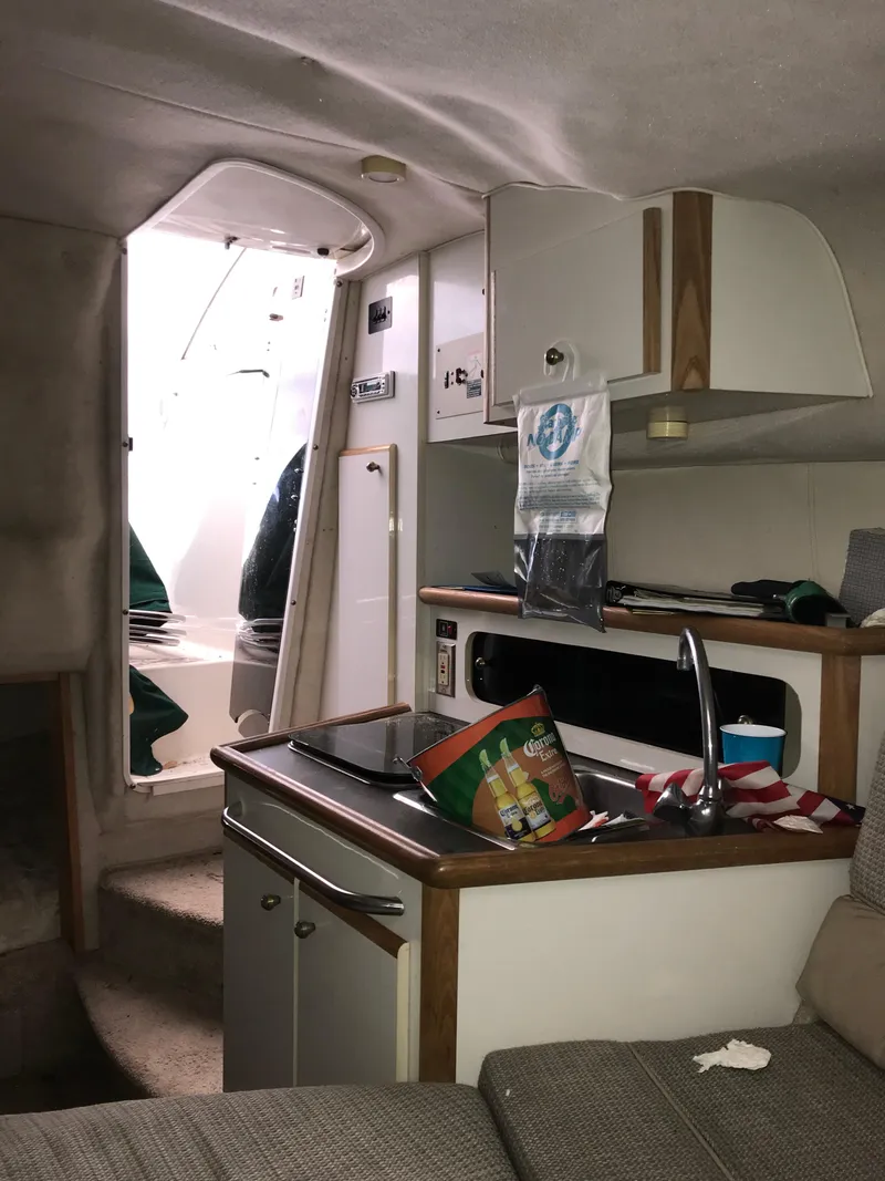 Slide: The Image of Interior of a 1996 Maxum 2400 SCR boat with kitchenette and seating area. - 26