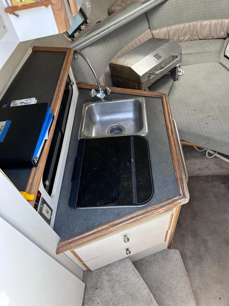 Slide: The Image of 1996 Maxum 2400 SCR boat interior kitchen with sink and seating area. - 5