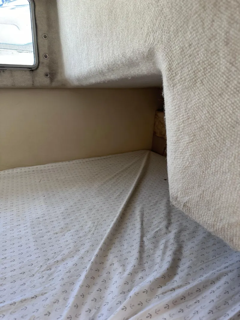 Slide: The Image of Interior cabin bed of a 1996 Maxum 2400 SCR boat with anchor-patterned sheets. - 8