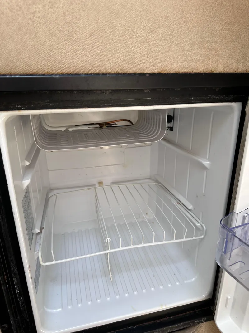 Slide: The Image of Empty refrigerator inside a 1996 Maxum 2400 SCR boat. - 9