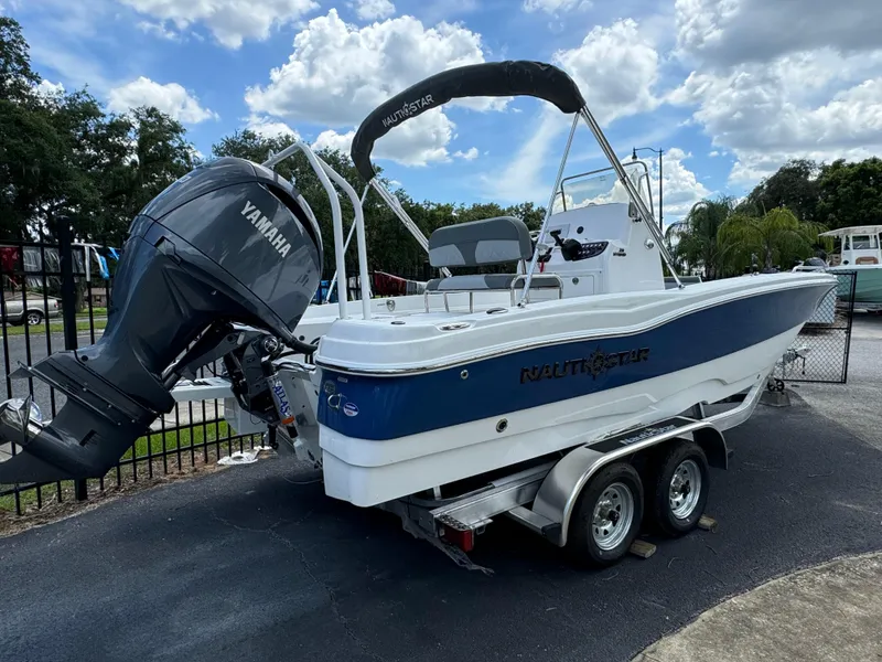 Slide: The Image of 2024 NauticStar 211 Hybrid boat with Yamaha engine on trailer. - 2