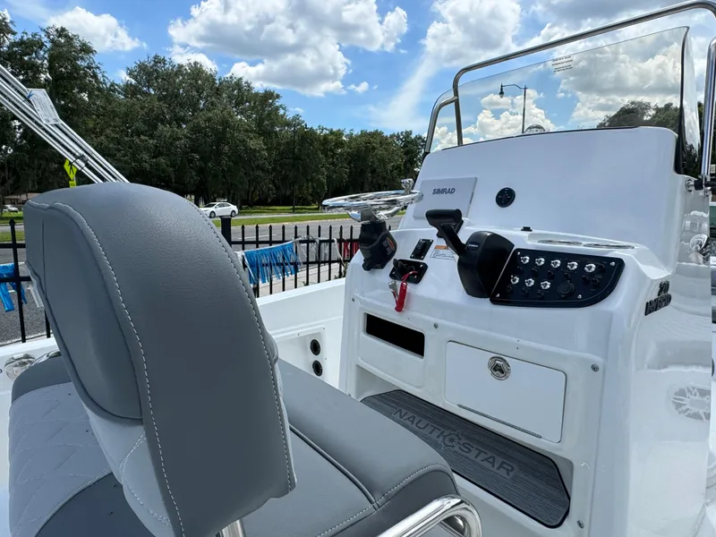 Slide: The Image of 2024 NauticStar 211 Hybrid boat console and seating area. - 3