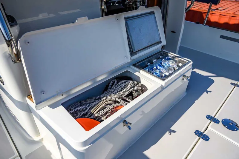 Slide: The Image of Open storage compartment on 2023 Targa 46 boat with ropes and bottled water. - 15