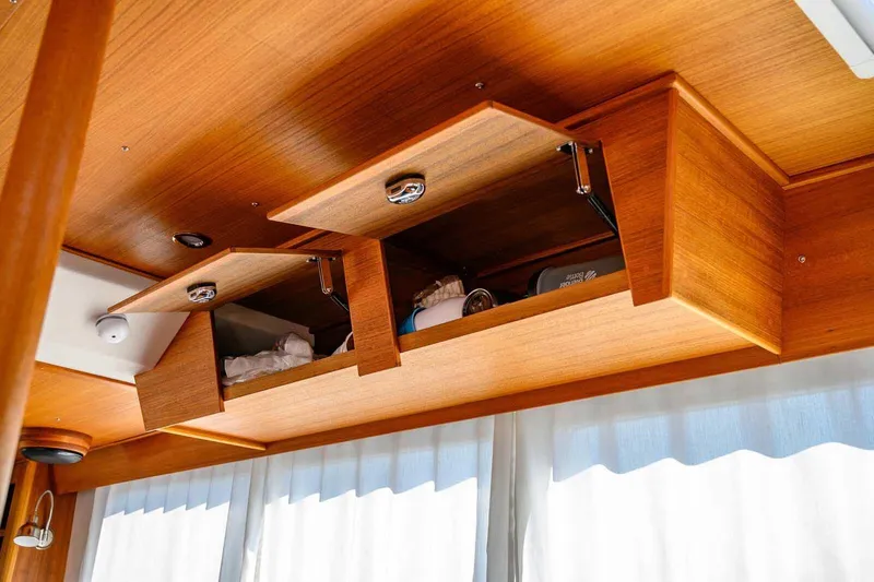 Slide: The Image of Wooden interior storage cabinets in 2023 Targa 46 boat, open to reveal contents. - 26