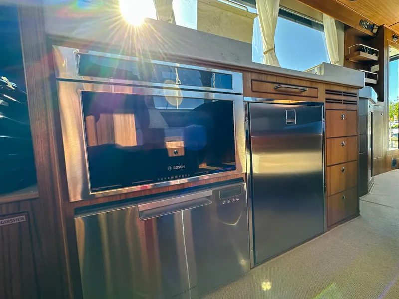 Slide: The Image of Modern kitchen interior on 2023 Targa 46 yacht with stainless steel appliances and sunlight streaming in. - 28