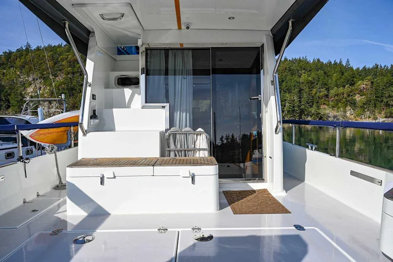 Slide: The Image of 2023 Targa 46 yacht deck with seating, glass doors, and scenic forest view. - 3
