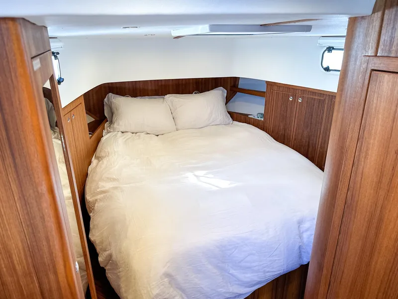 Slide: The Image of Cozy bedroom in 2023 Targa 46 yacht with wooden interior and white bedding. - 33