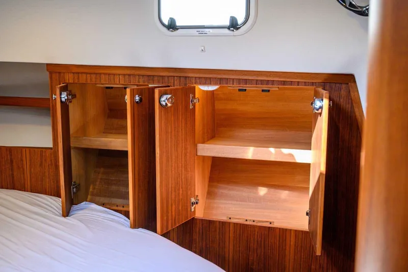 Slide: The Image of 2023 Targa 46 interior with open wooden cabinets and a window. - 34