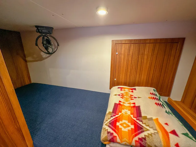 Slide: The Image of Cozy cabin interior of 2023 Targa 46 with colorful blanket and wooden accents. - 36