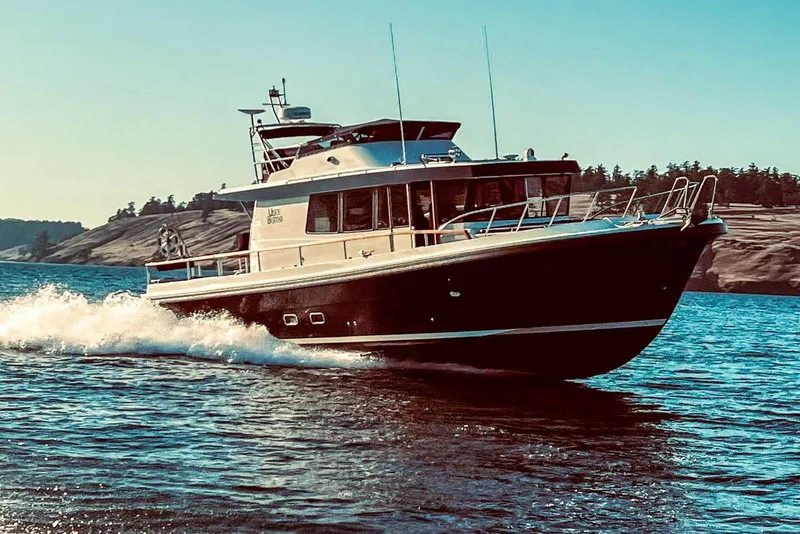 Slide: The Image of 2023 Targa 46 boat cruising on a sunny day near rocky shoreline. - 41