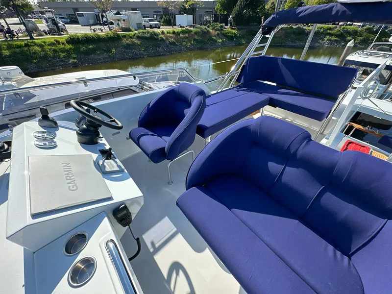 Slide: The Image of Luxurious 2023 Targa 46 yacht with blue seating and modern helm, docked by a serene river. - 8