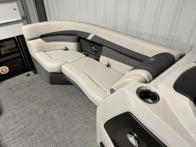 Slide: The Image of 2025 Barletta Cabrio C22UC boat interior with luxurious seating in a garage setting. - 12