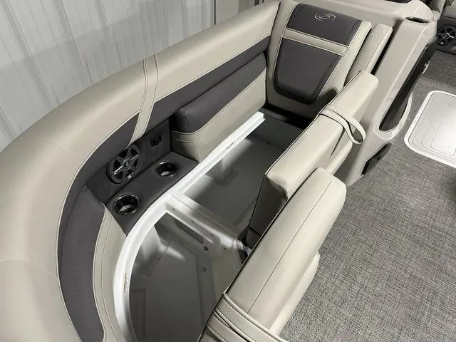 Slide: The Image of 2025 Barletta Cabrio C22UC boat interior with plush seating and modern design in a showroom. - 16