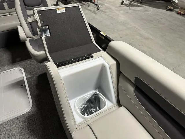 Slide: The Image of 2025 Barletta Cabrio C22UC boat interior with open storage compartment and plush seating. - 18