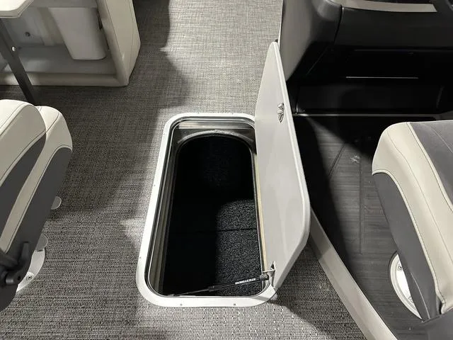 Slide: The Image of 2025 Barletta Cabrio C22UC boat interior with seating and table in a garage setting. - 22