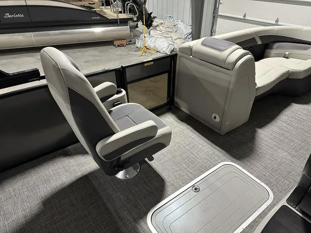 Slide: The Image of 2025 Barletta Cabrio C22UC boat interior seating with cup holders in showroom. - 8