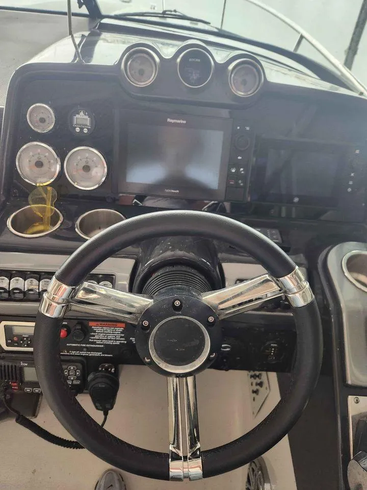 Slide: The Image of 2018 Formula 310 Sun Sport boat dashboard with steering wheel and navigation controls. - 17