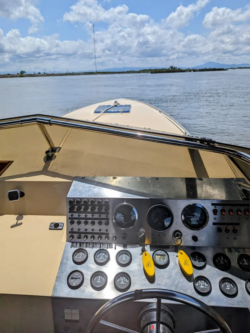 Slide: The Image of 1980 Tahiti Ocean Racer boat dashboard with gauges, steering wheel, and open water view. - 4