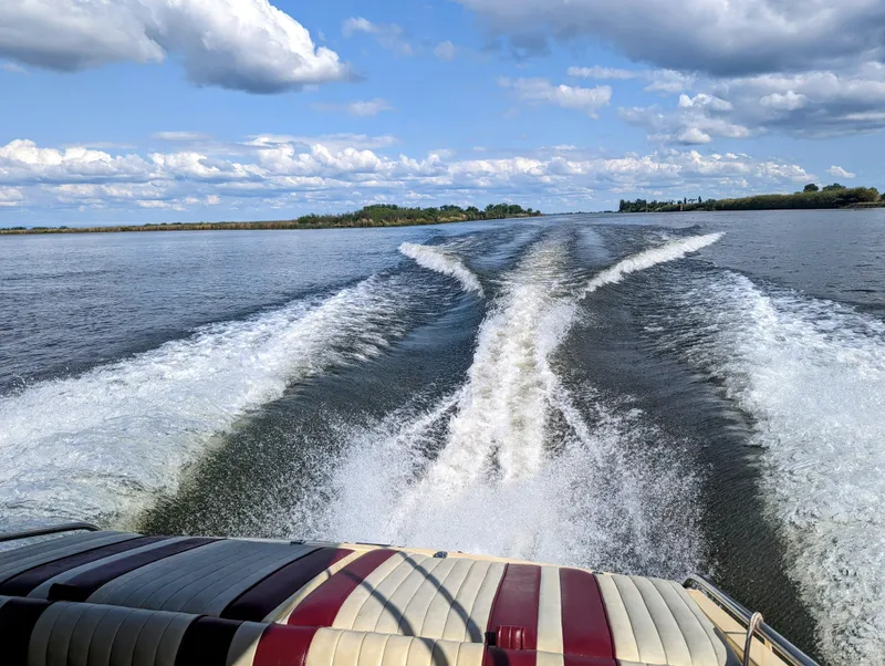 Slide: The Image of 1980 Tahiti Ocean Racer speeding on a lake, leaving a wake under a partly cloudy sky. - 6