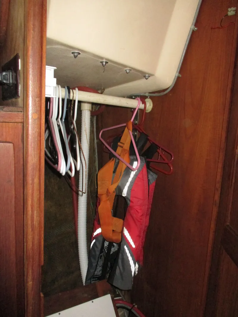 Slide: The Image of Small closet in a 1979 CAL 31 sailboat with hangers and life jacket. - 10