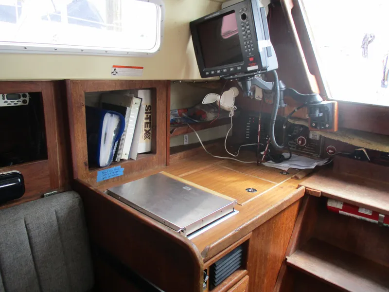 Slide: The Image of Navigation station inside a 1979 CAL 31 sailboat with equipment and storage. - 16