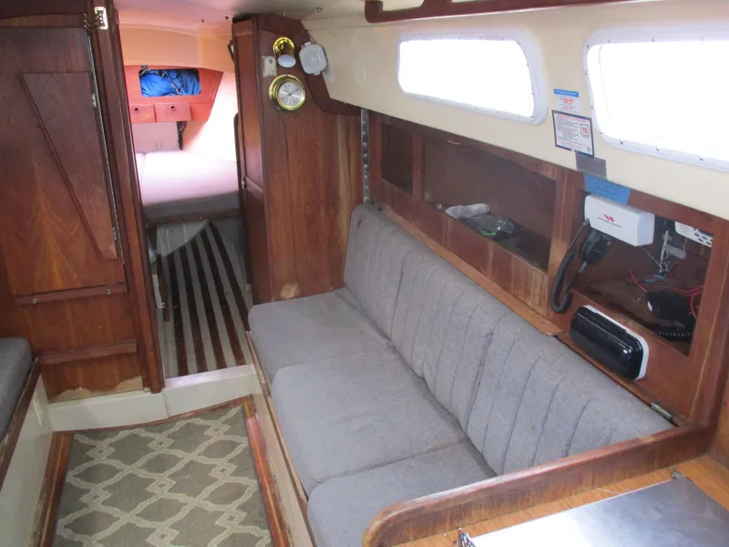 Slide: The Image of Interior of a 1979 CAL 31 sailboat with wooden furnishings and a cozy seating area. - 17