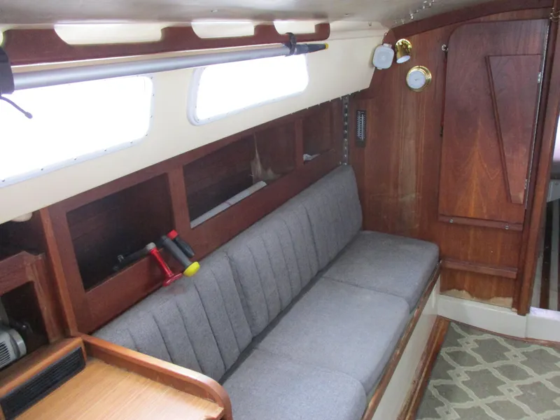 Slide: The Image of 1979 CAL 31 sailboat interior with gray seating, wooden paneling, and nautical instruments. - 18