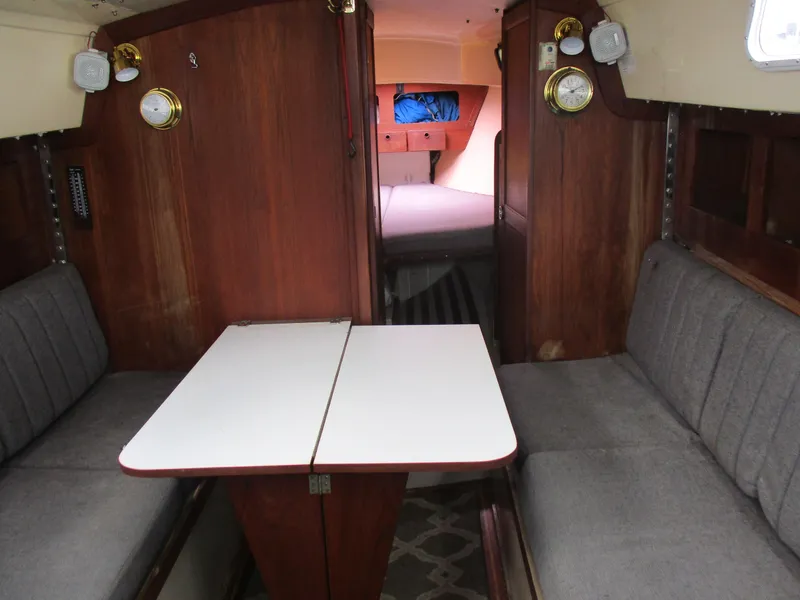 Slide: The Image of Interior of a 1979 CAL 31 sailboat with wooden paneling and gray seating. - 20