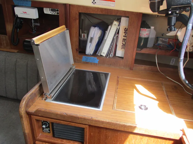 Slide: The Image of Navigation station inside a 1979 CAL 31 sailboat with equipment and storage. - 21