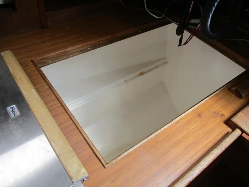 Slide: The Image of Wooden interior of a 1979 CAL 31 boat, featuring a storage compartment. - 23