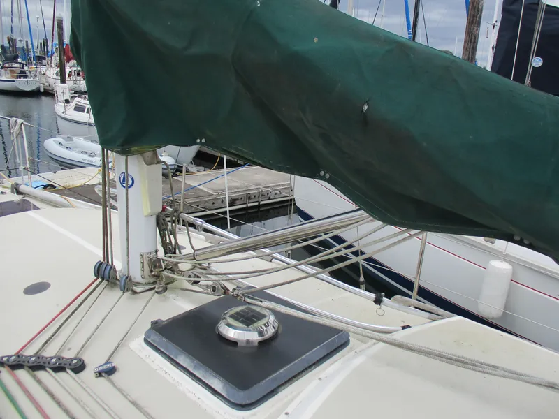 Slide: The Image of 1979 CAL 31 sailboat deck with green cover, docked at marina. - 3