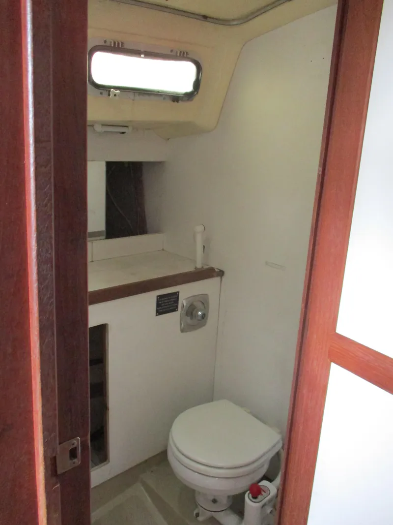 Slide: The Image of 1979 CAL 31 boat bathroom with toilet, sink, and wooden accents. - 9