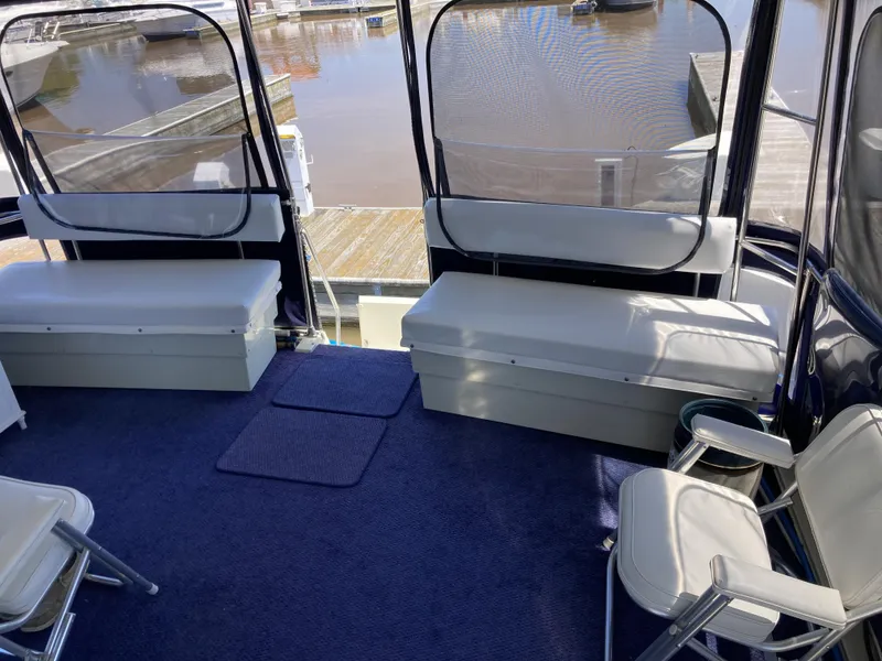 Slide: The Image of 1987 Tollycraft 44 Cockpit Motor Yacht interior with seating and marina view. - 10