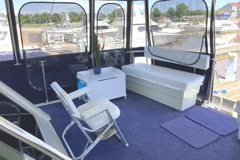 Slide: The Image of 1987 Tollycraft 44 Cockpit Motor Yacht interior with seating and marina view. - 13