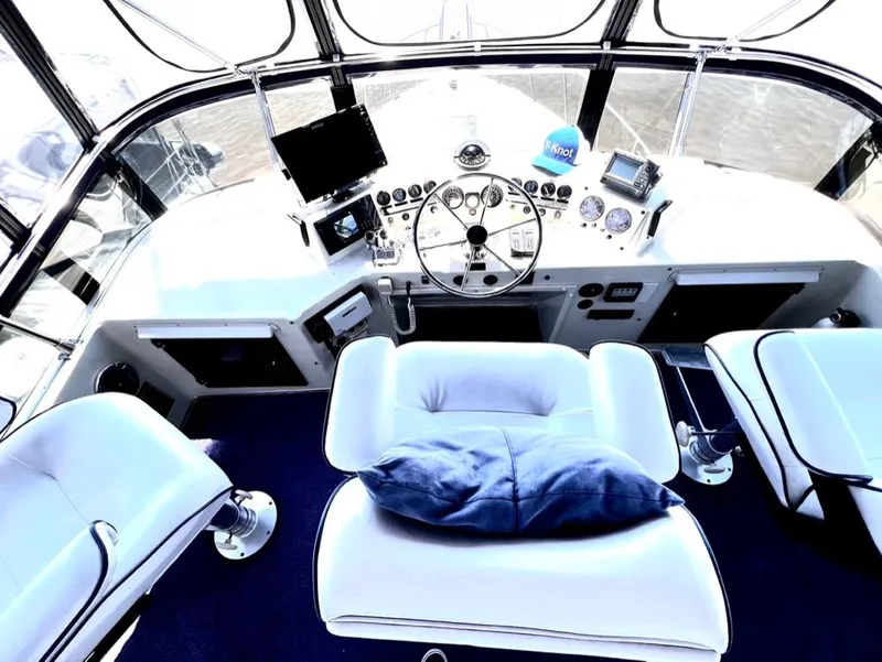 Slide: The Image of 1987 Tollycraft 44 Cockpit Motoryacht helm with modern navigation equipment and plush seating. - 16